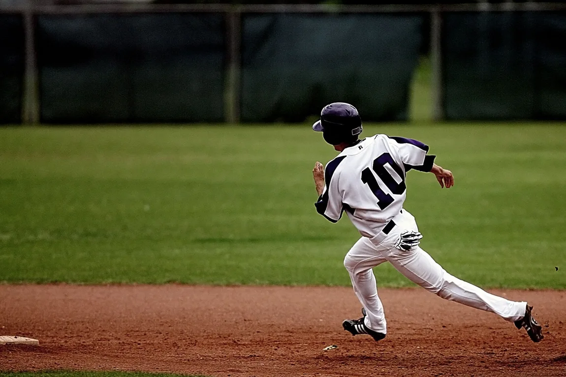 A baseball runner sprinting between bases mid-stride