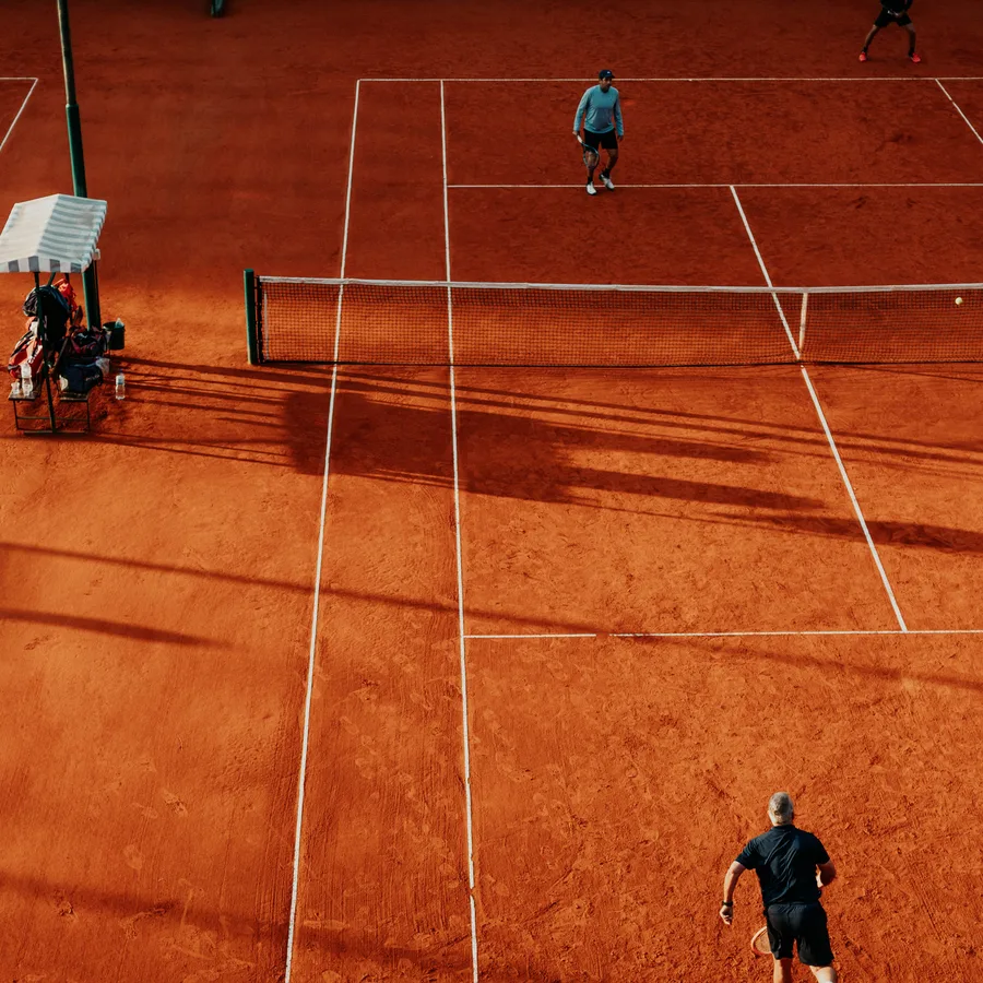 An aerial view of two players rallying on a clay tennis court