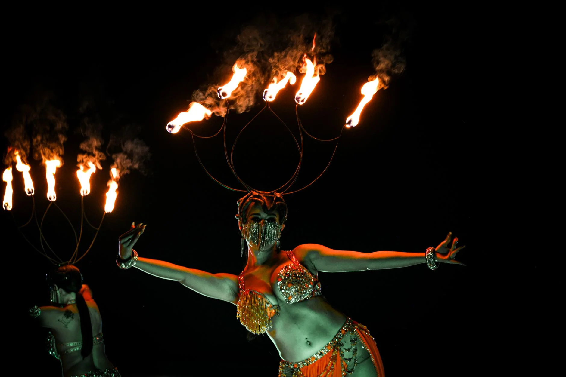 A fire performer dancing with flames at night