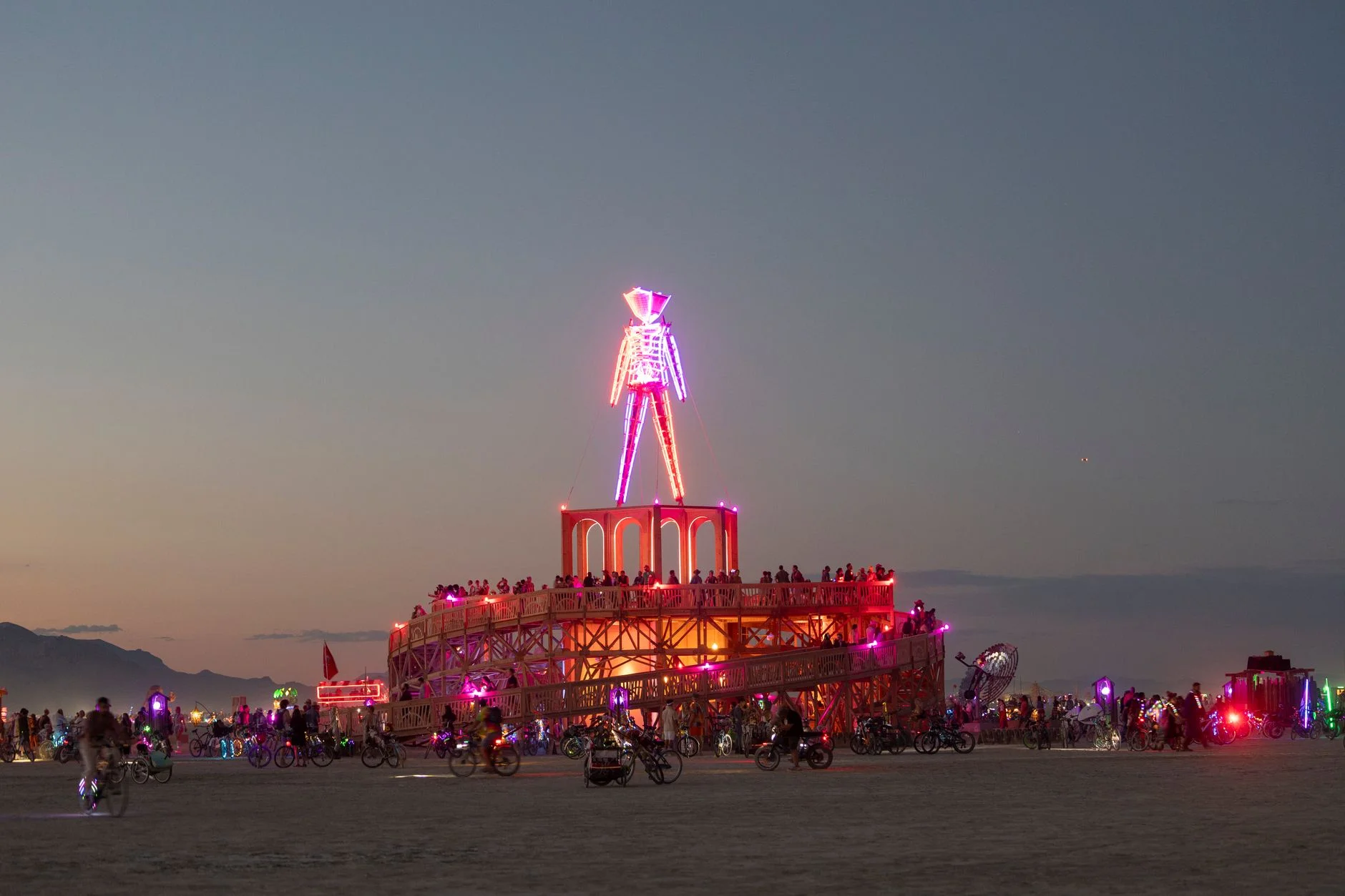 An illuminated art installation glowing at night during a desert arts festival