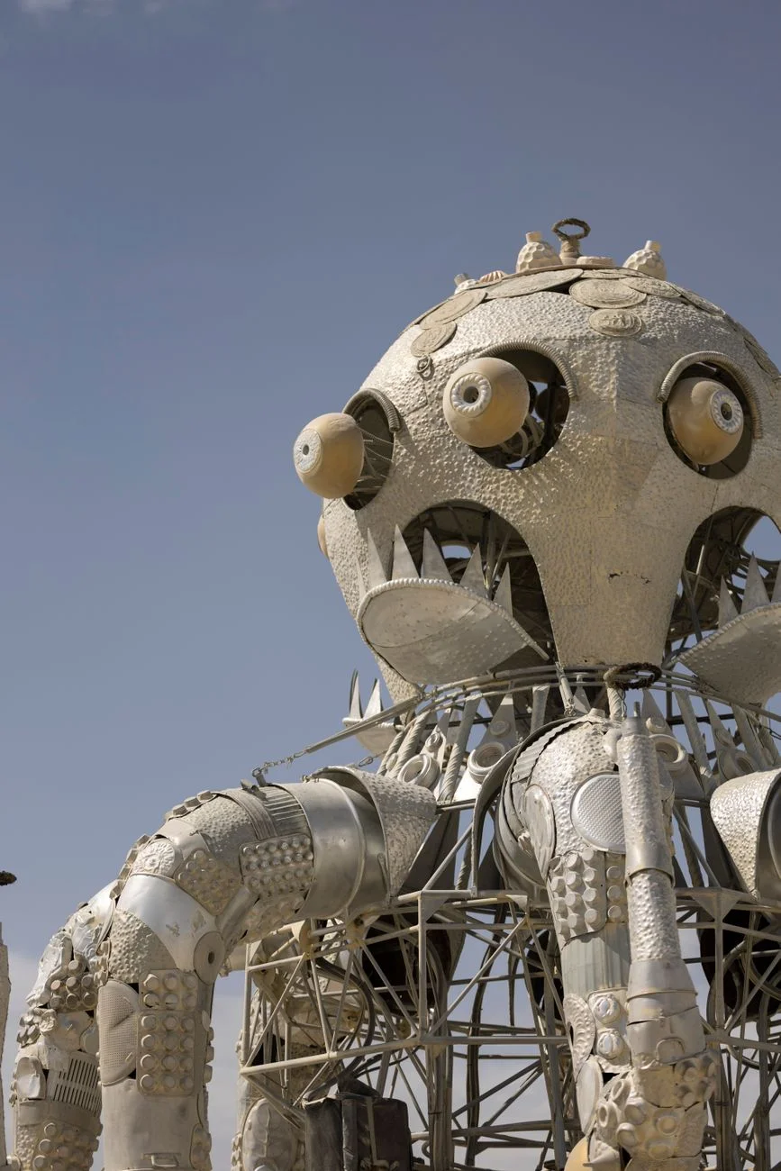 A large metallic octopus sculpture at a desert arts festival