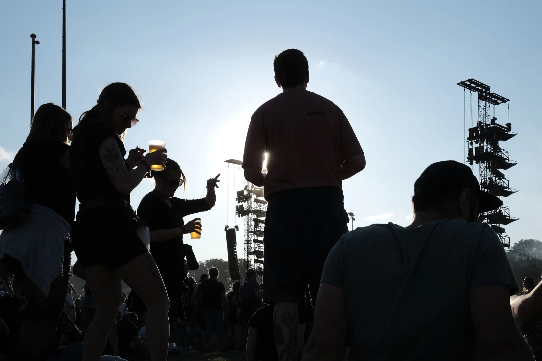 Silhouettes of a festival crowd celebrating at sunset