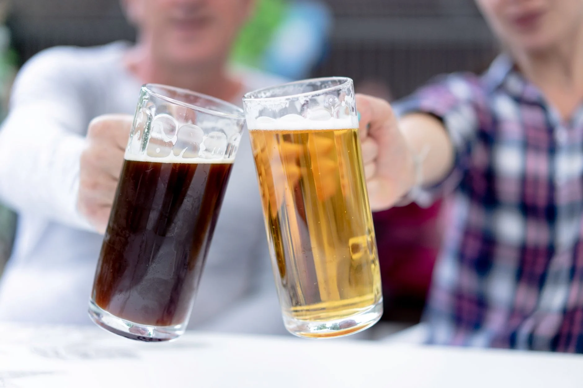 Two people clinking large beer steins together at Oktoberfest