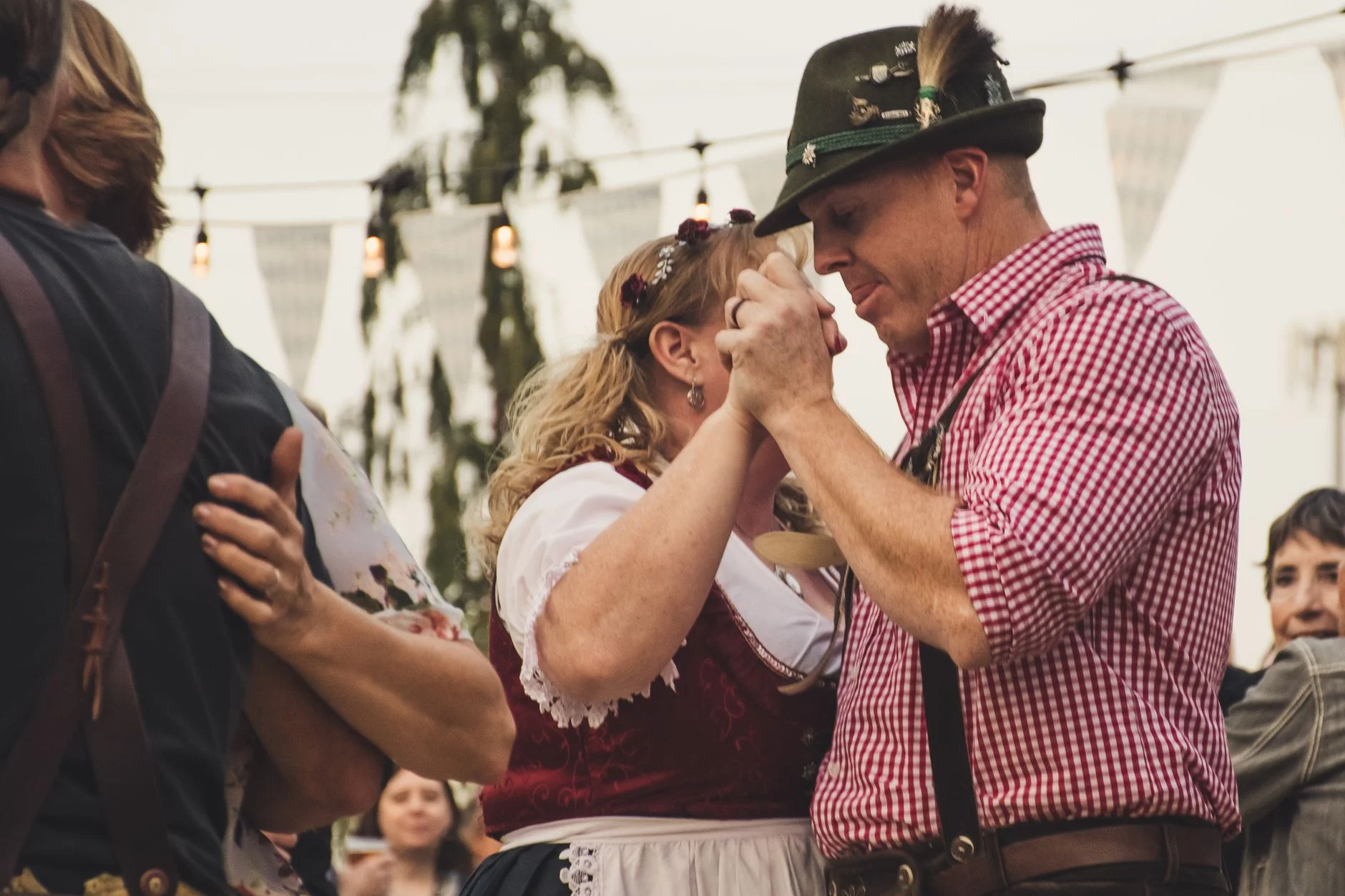 A festive couple dancing together at an Oktoberfest celebration