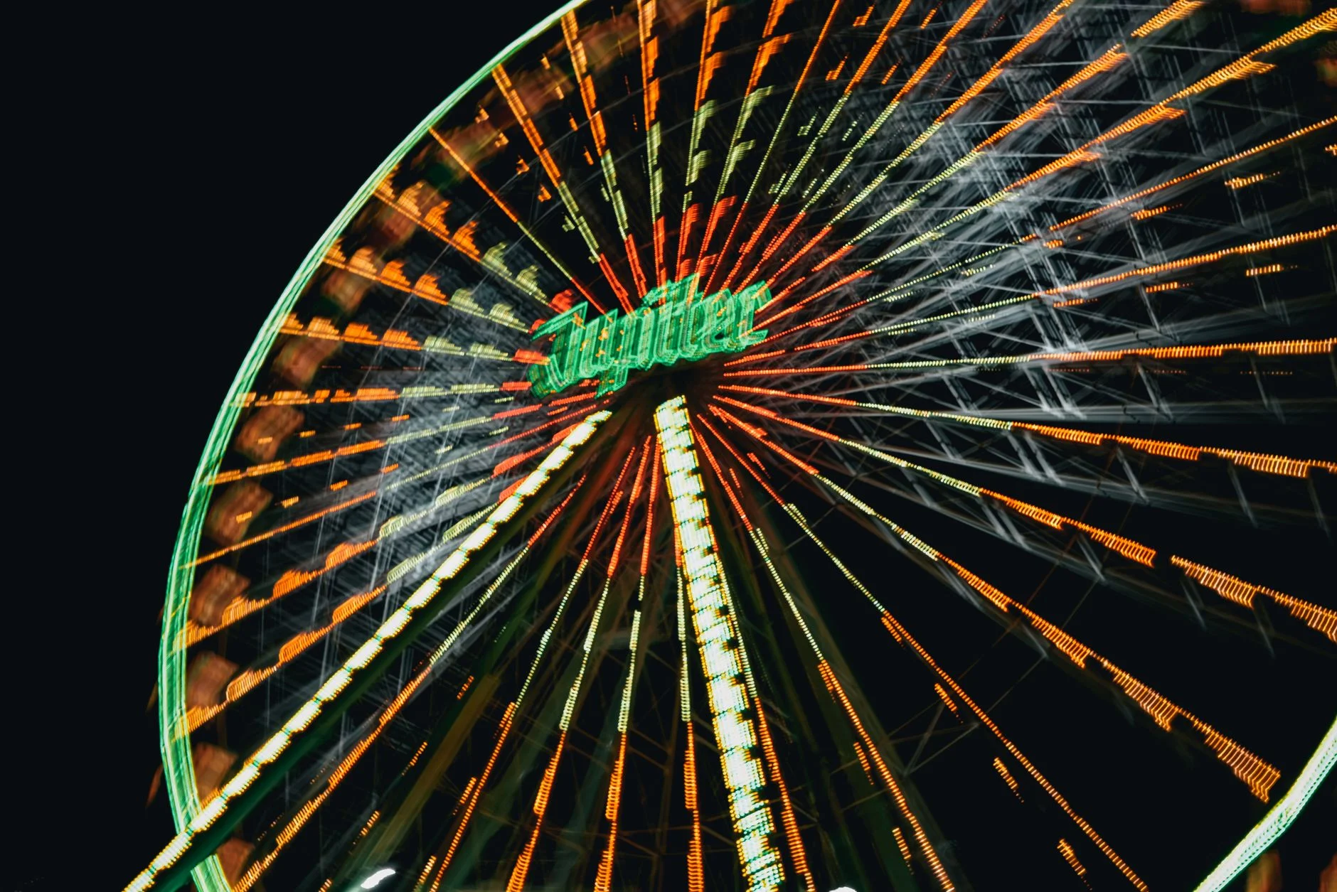 A brightly lit fairground ride captured in motion at night