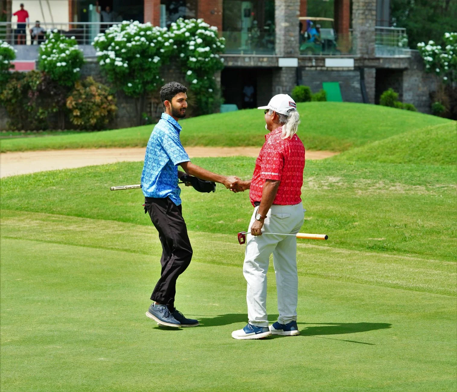 Two golfers shaking hands on a course