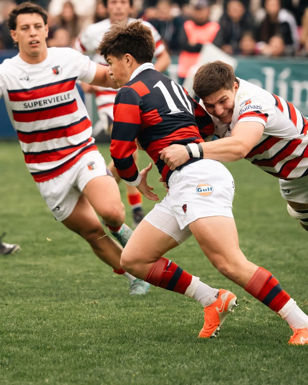 A rugby league player being wrapped up in a tackle during a match