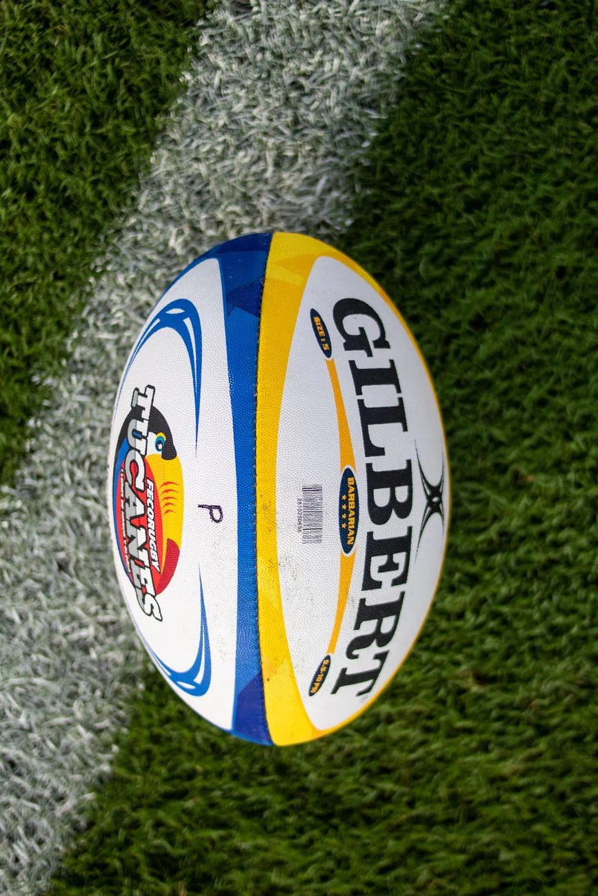 Close-up of a rugby ball resting on a grass field