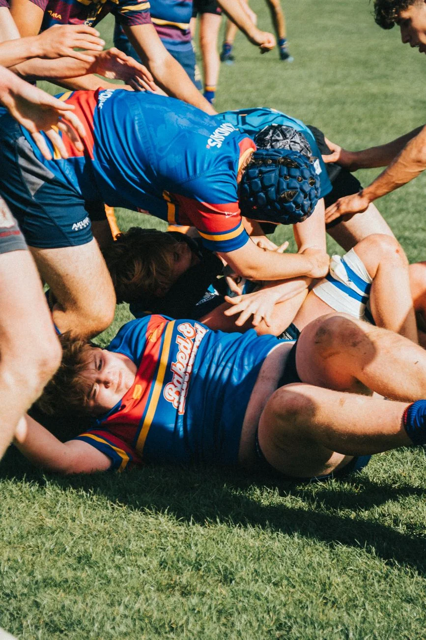 A rugby player being tackled to the grass mid-match